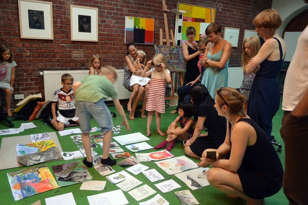 Kinder und Eltern sehen sich im Atelier in der Brunnenstraße die Arbeiten an