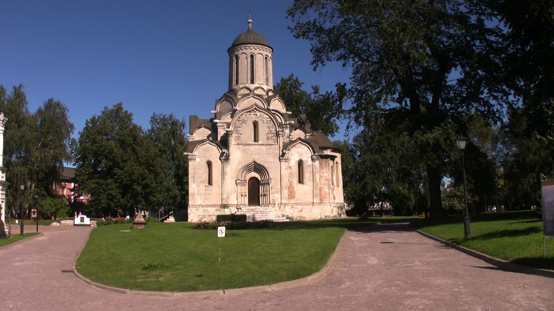 Weiße Steinkirche mit Kuppel in einem Park an einem sonnigen Tag.