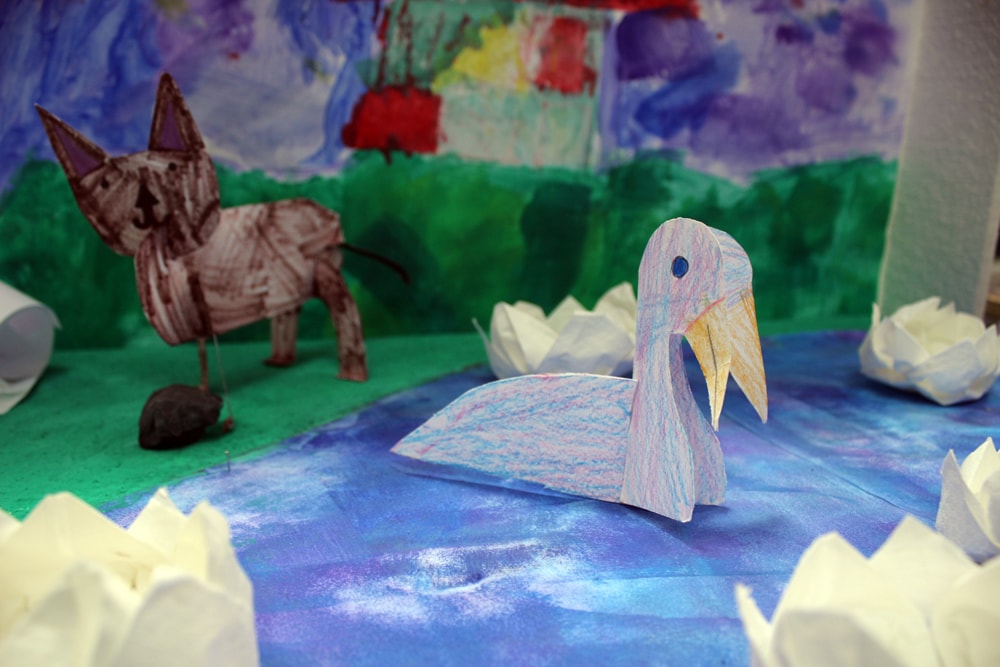 Tiere aus Papier in einer bemalten Landschaft