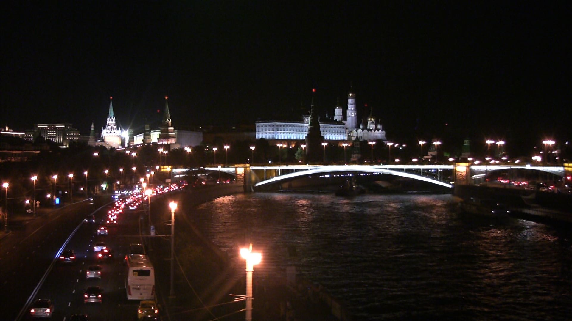 Nächtliche Moskwa mit beleuchteter Brücke und Kreml im Hintergrund.
